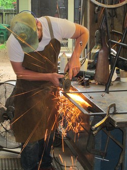 Artistic blacksmith Jason Smith working on the gun-fashioned rope pump.