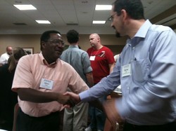 Two men shaking hands at a conference.