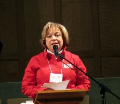 Clergywoman speaking at microphone