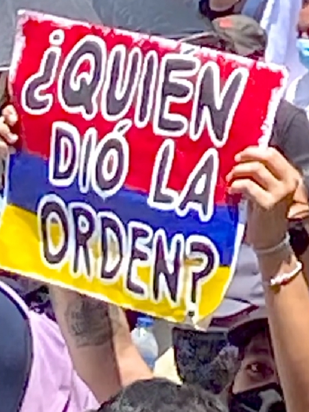 Un manifestante en Medellín sostiene un cartel con la pregunta: 