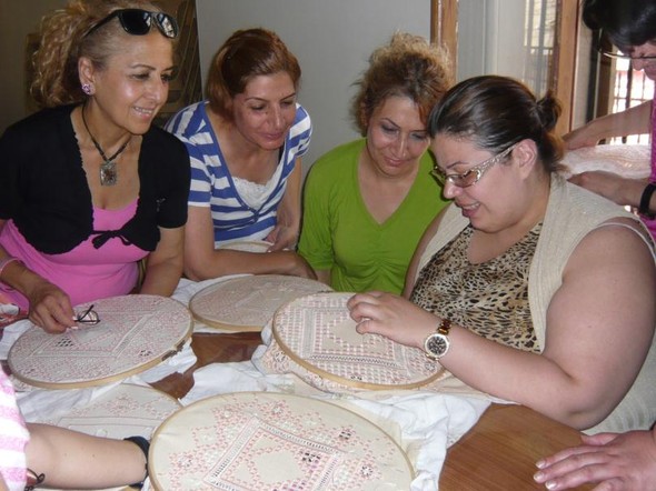 Four women smile over their handiwork