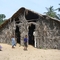 The outside of Isalele church's building. They constructed out of bamboo poles and palm fronds.