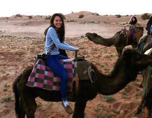 Emily Chun riding a camel in the Sahara Desert.