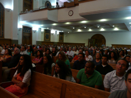 A group of people in a Middle Eastern church during worship.