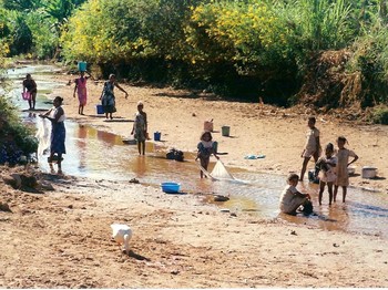 Women and children in Madagascar gather water and wash clothes in a stream far from their village. Lack of access to clean, abundant, and close water also contributes to poverty and vulnerability to being trafficked.