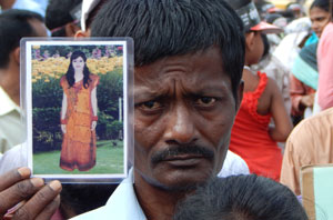 Bangladeshi man holds up picture of wife killed in garment factory collapse in 2013